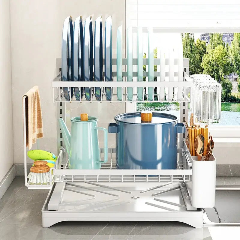 White two-tier metal dish drying rack with wire mesh shelves holding plates pots and utensils for kitchen storage