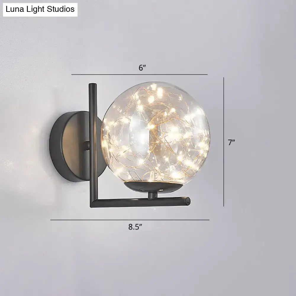 Modern black mini globe wall sconce with clear glass globe housing warm fairy lights and compact fixture height