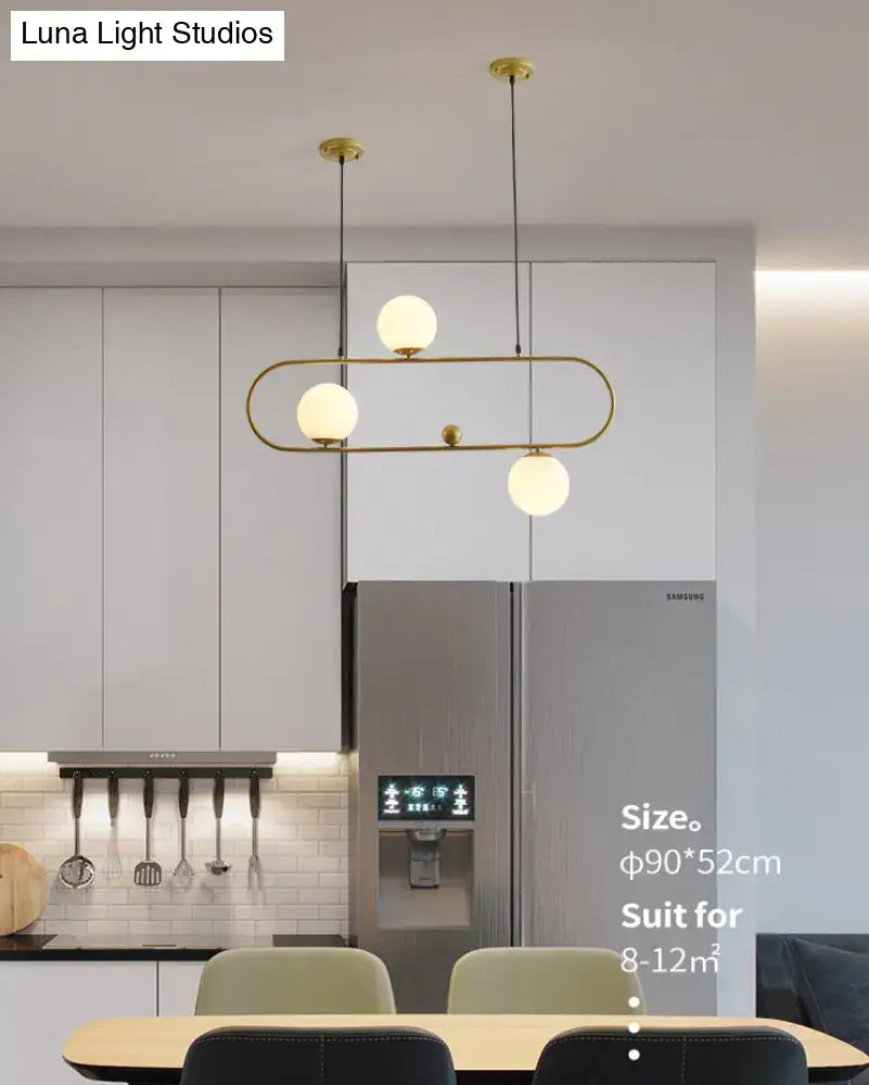 Gold-toned modern pendant ceiling light with three frosted glass globes in minimalist ellipse frame for living room
