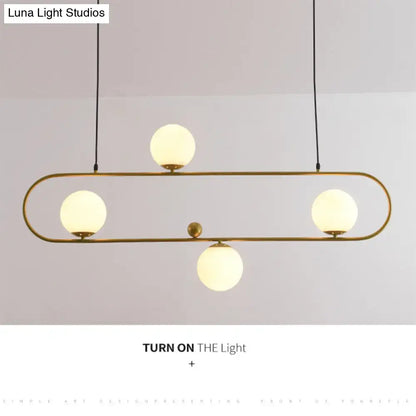 Modern brass-finished ceiling light with four frosted glass globes in a minimalist ellipse frame for living room use