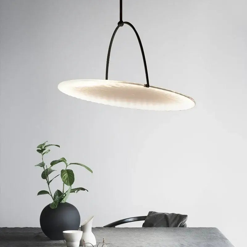Modern black minimalist led pendant light with frosted circular glass shade softly glowing for living room use