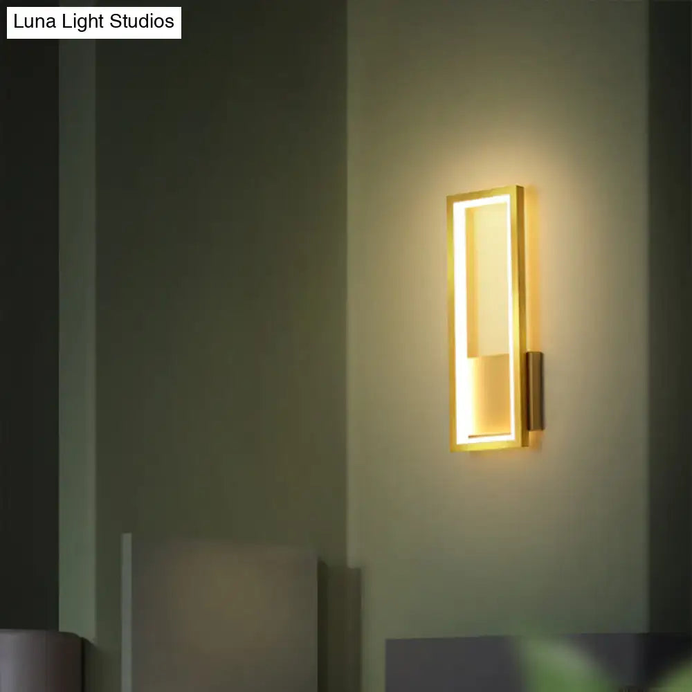 Modern black minimalist LED wall sconce with a sleek gold-finished frame and warm glowing light for foyer use