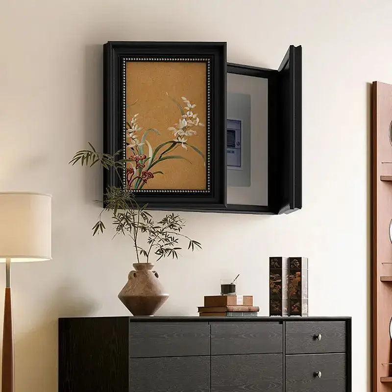 Modern black-framed wall-mounted mirror meter box cover with hinged door and decorative beaded trim for electric meter box