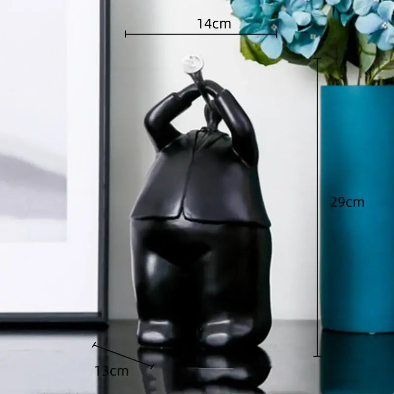 Modern black glossy resin musical instrument band figurine in formal attire holding small white object for living room decor