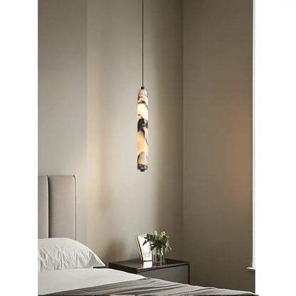 Modern black natural marble stone pendant light with a warm glowing interior and layered natural stone exterior for kitchen