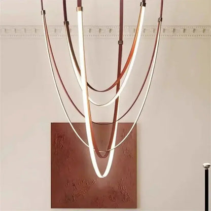 Modern pendant light with curved warm white led strips and copper tones suspended by black and orange leather belts for dining rooms