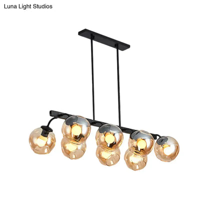 Modern black metal chandelier with five amber glass globe shades featuring orb shade design for kitchen and dining room