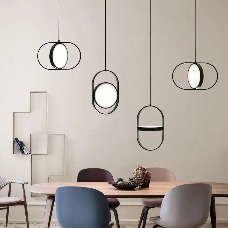 Modern black oval decorbites adjustable angle pendant light with minimalist geometric frame hangs above dining table