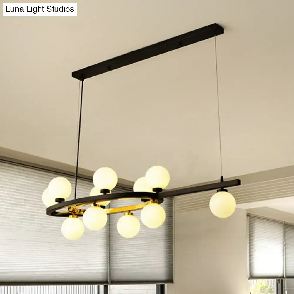 Modern black oval hanging light fixture chandelier featuring gold accents and frosted glass globe bulbs for dining room