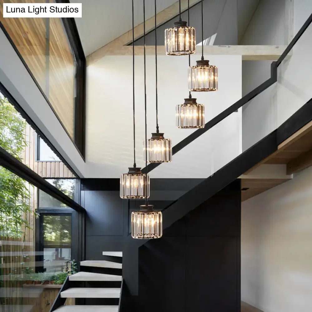 Five decorbites™ modern prismatic crystal cylindrical pendant lights with black metal fixtures illuminate a stairway