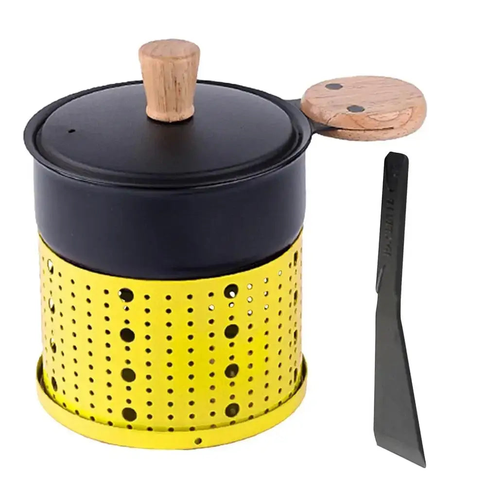 Yellow perforated metal pot with black lid and wooden handles with black spatula in modern black raclette fondue set