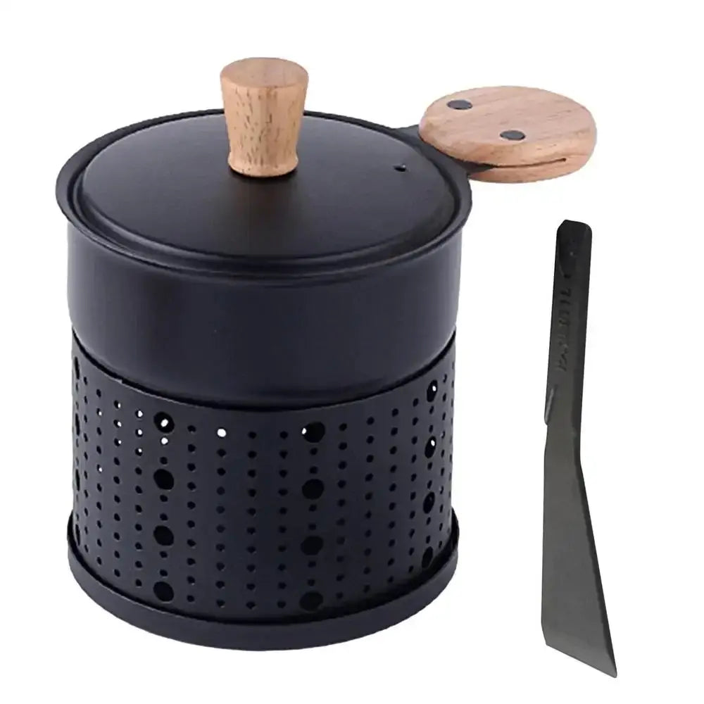 Modern black raclette fondue set featuring a perforated metal charcoal grill with wooden lid knob and matching spatula