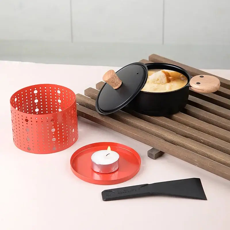 Modern black raclette fondue set with wooden lid and handle showing a creamy dish in a black pot for dining room grill