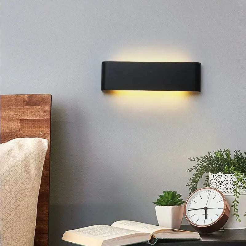 Modern black rectangular led wall lamp emitting a warm yellow glow ideal for bedroom lighting