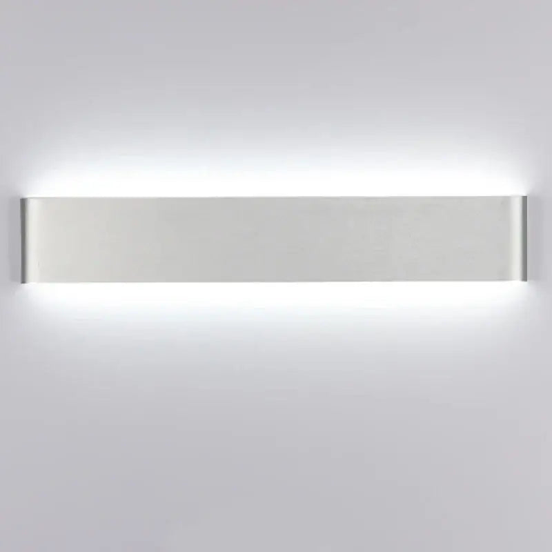 Modern silver rectangular led wall lamp with sleek minimalist design providing warm glow for bedroom lighting
