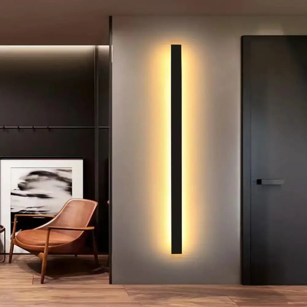 A sleek black modern rectangular led wall lamp emitting warm light for living room use