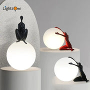 Modern black and red resin abstract humanoid table lamp with glowing white spherical ball holder for bedroom decorbites decor