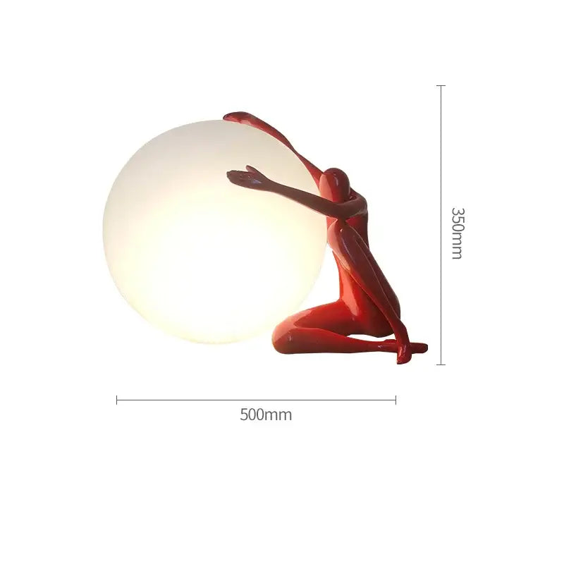 A glossy red table lamp with a humanoid ball holder design cradling a glowing white sphere for modern decorbites abstract decor