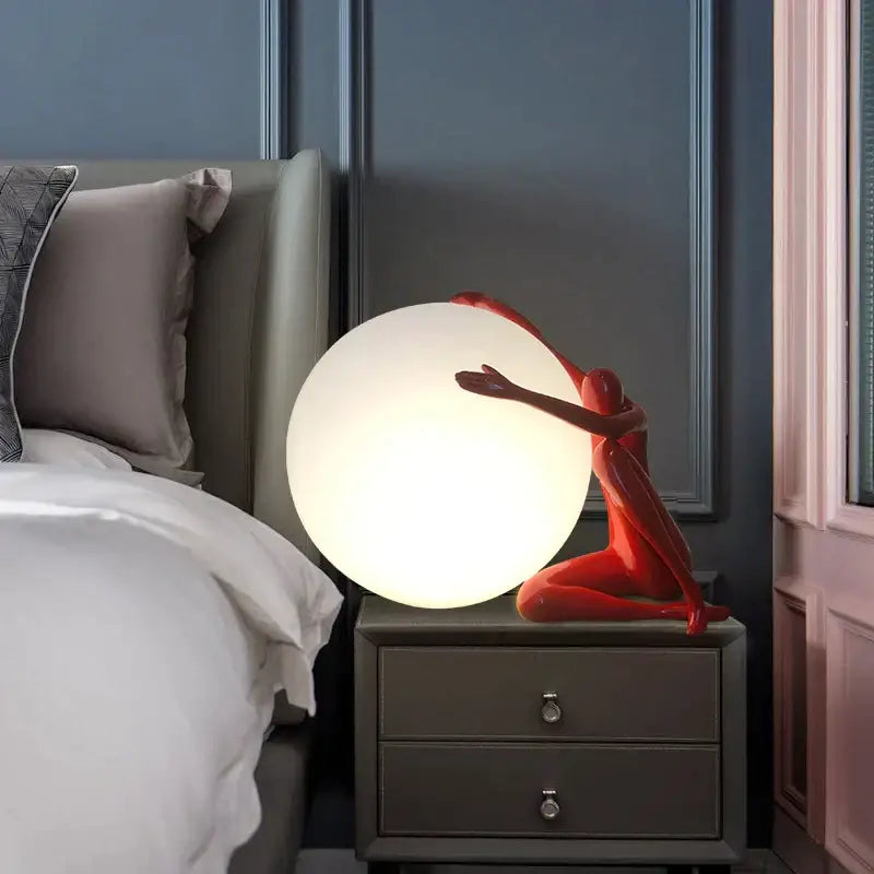 Modern black and red humanoid ball holder table lamp with glowing spherical light and smooth resin decorbites abstract design