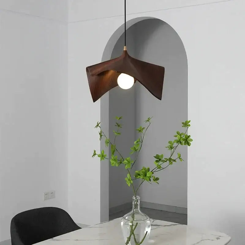 Dark brown wooden pendant chandelier with sleek sculpted design and central bulb for modern black resin led decorbites