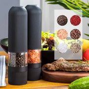 Modern black ribbed automatic salt pepper grinder set with transparent glass revealing peppercorns and pink himalayan salt