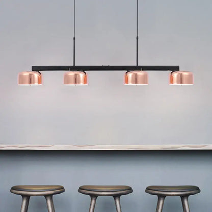 Modern black rose gold diner island lamp with copper finish and four cylindrical lampshades on sleek black bar