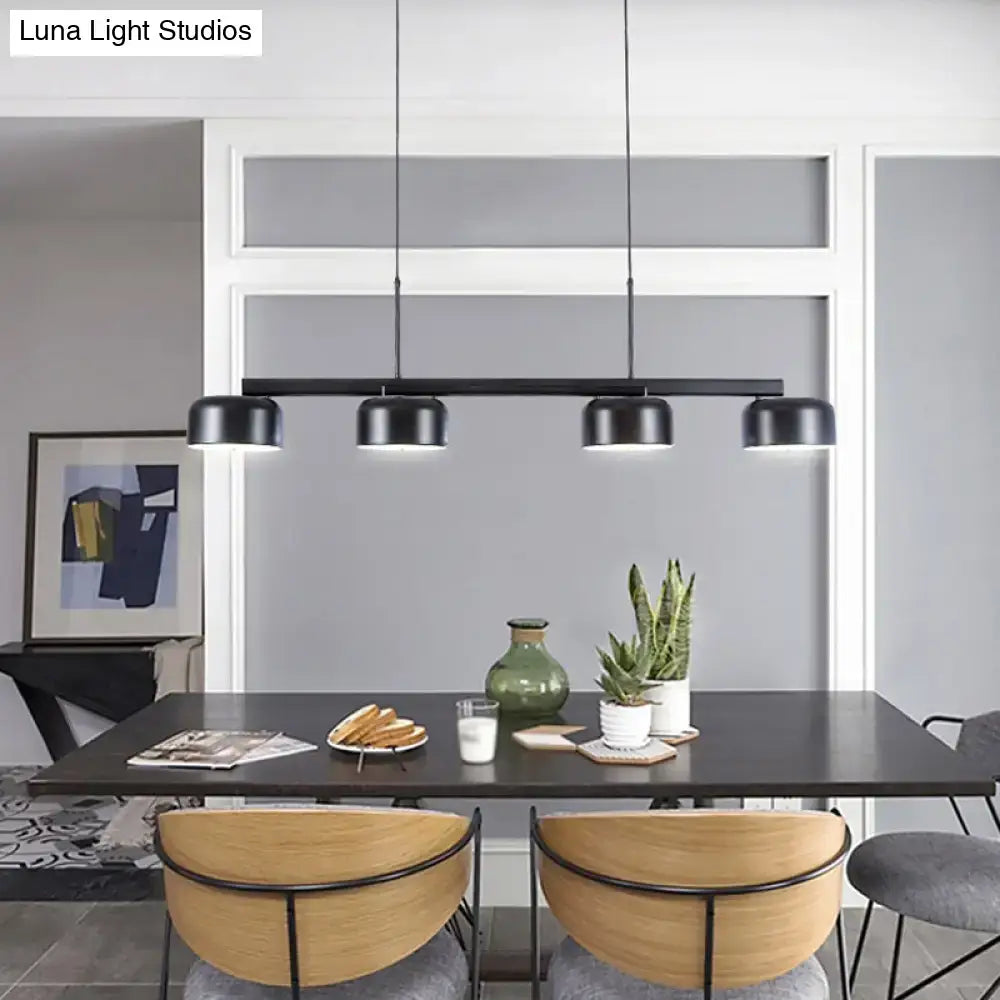 Modern black rose gold diner island lamp with four cylindrical shades pendant light above dining table