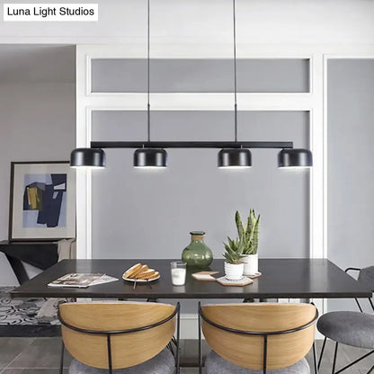 Modern black rose gold diner island lamp with four cylindrical shades pendant light above dining table
