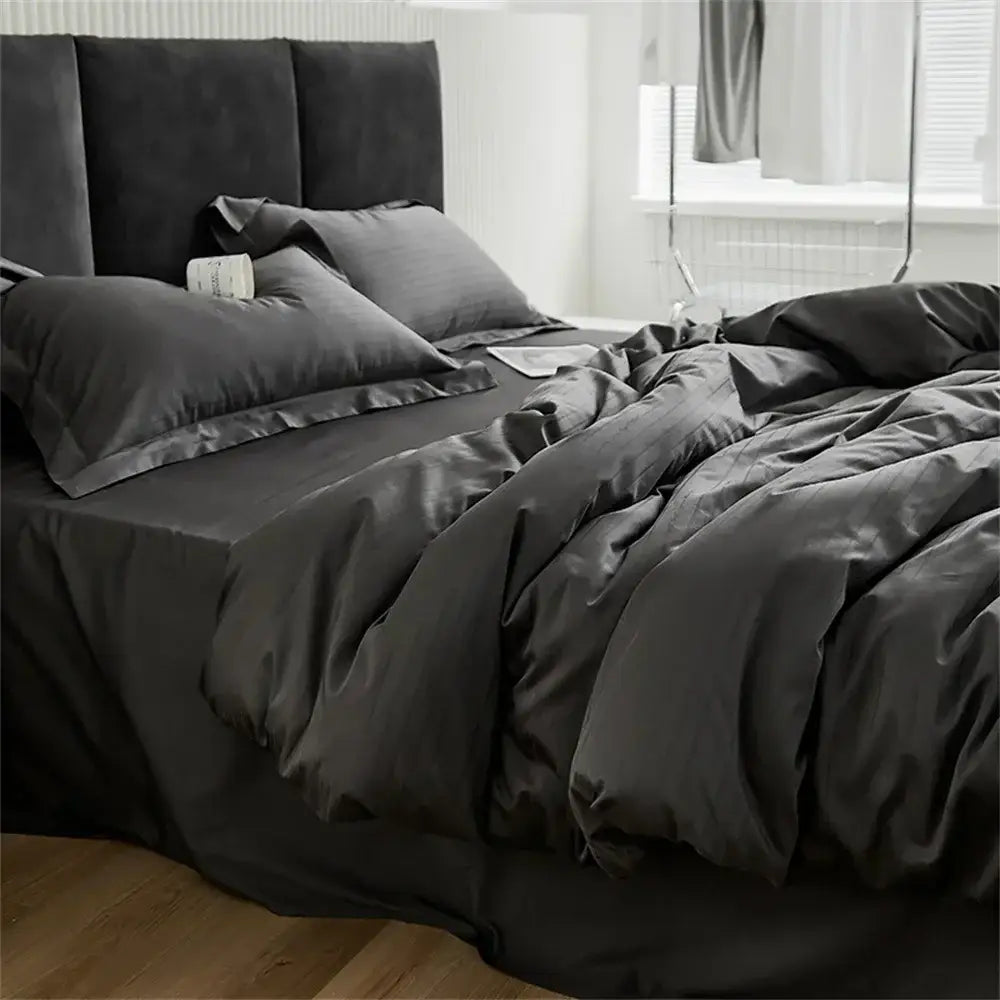 Modern black satin jacquard duvet cover set with matching pillowcases featuring a smooth glossy finish and elegant drape