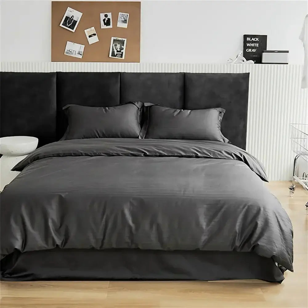 Modern black satin jacquard duvet cover set with matching pillows and bed skirt on a black upholstered headboard