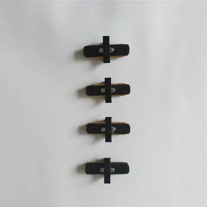 Black rubber bicycle brake pads with metallic hardware shown as part of decorbites ceiling track rail connector set