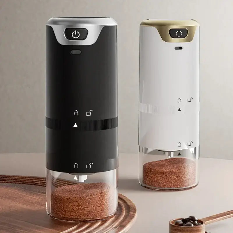 Two sleek modern black and silver electric coffee tamper barista grinders with glass bases filled with ground espresso coffee