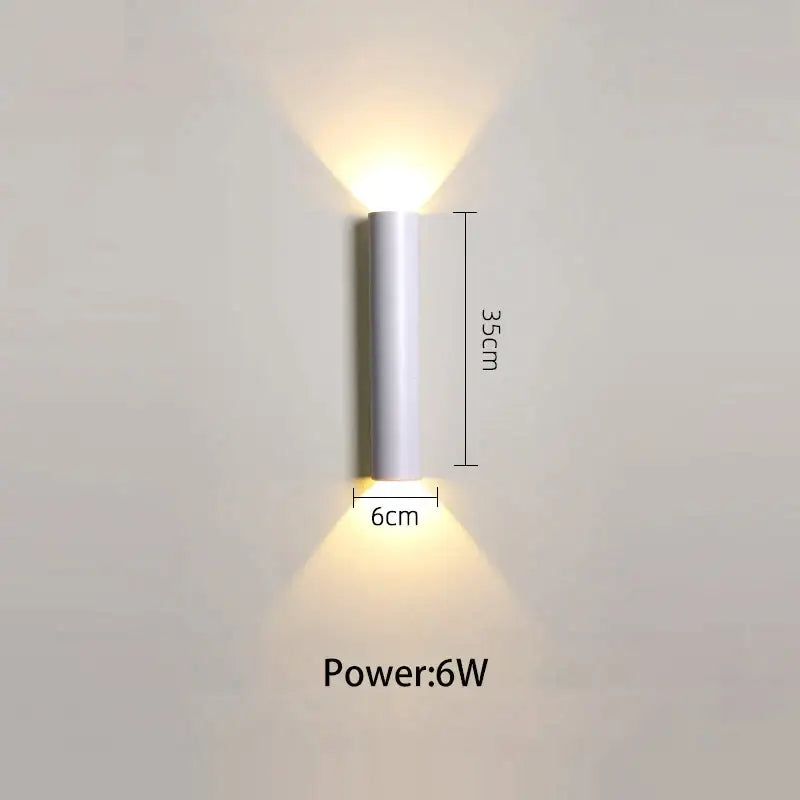 A sleek cylindrical white led wall lamp 35cm high 6cm wide providing modern up and down light sources