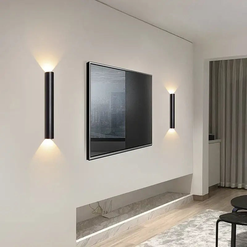 Modern black and silver led wall lamp with cylindrical design and warm focused lighting for bedroom or tv background