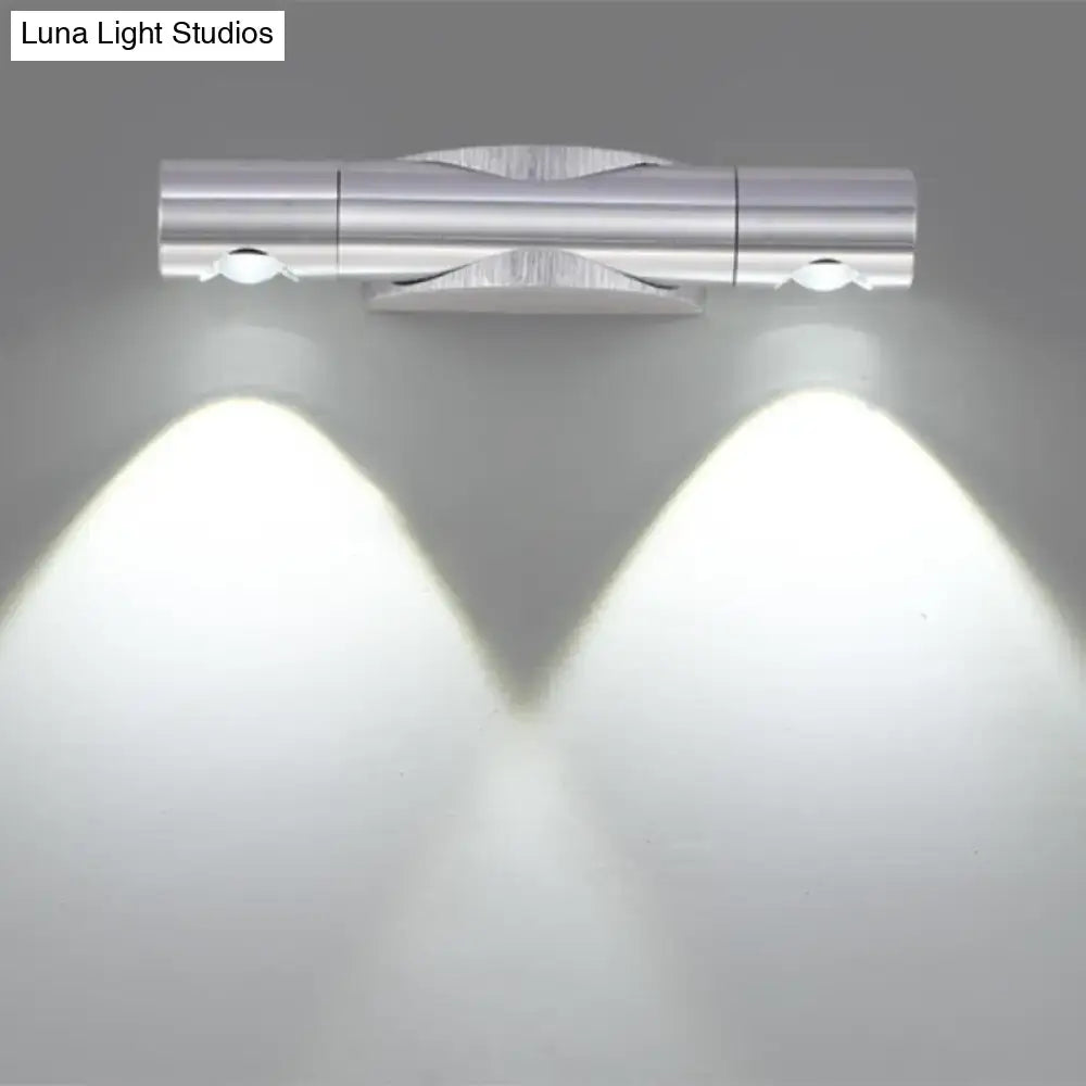 Silver metallic wall-mounted light fixture with two adjustable spotlights providing warm white lighting for living room