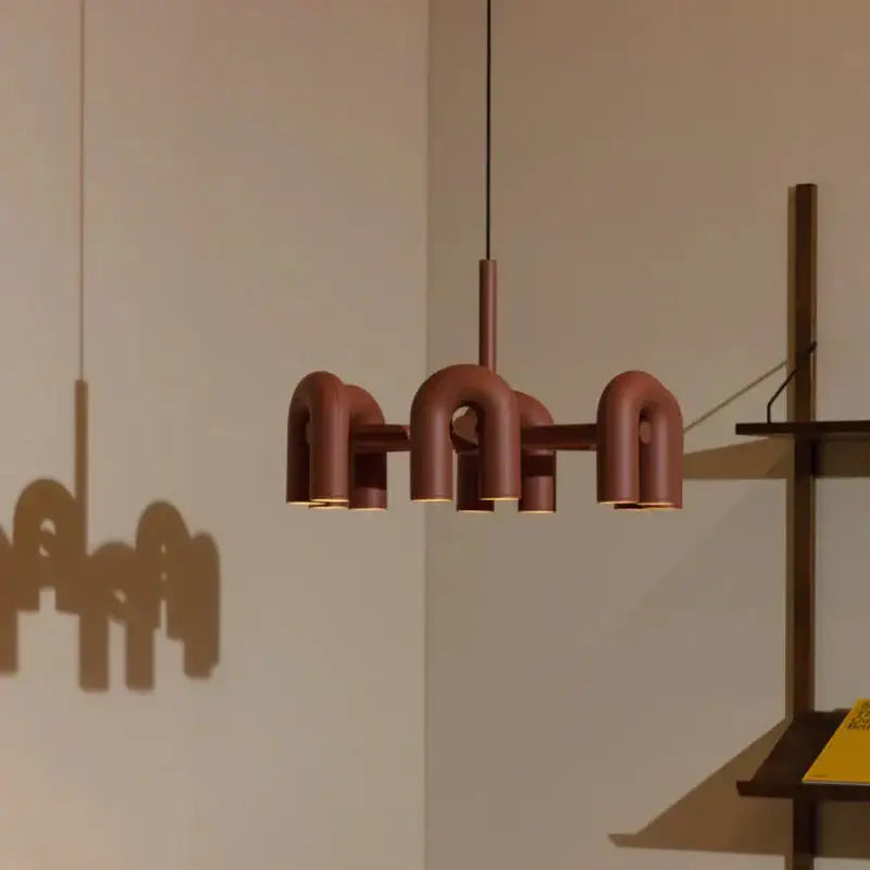 Modern terracotta-colored tube wall lamp with sleek u-shaped metal design for minimalist bedroom sconce lighting