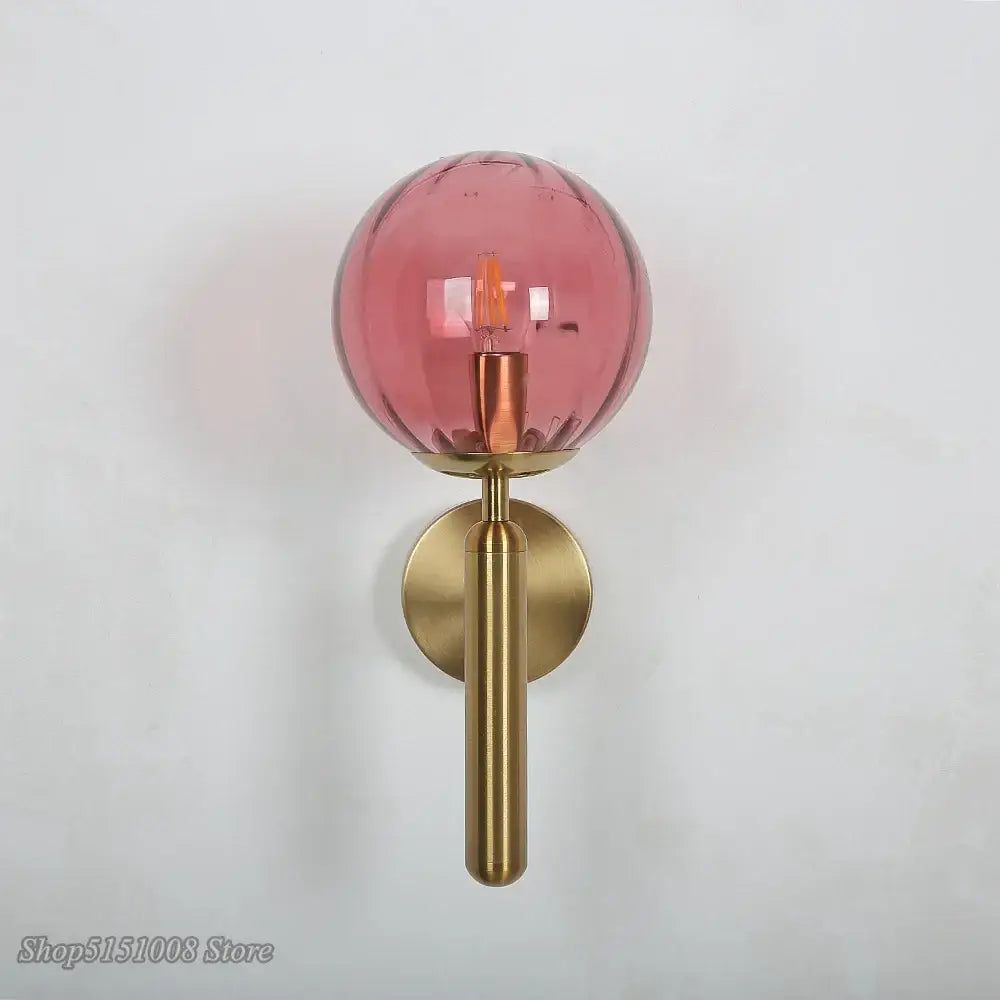 Modern black smoked glass ball led wall lamp with translucent pink decorbites glass ball and polished brass stem and backplate