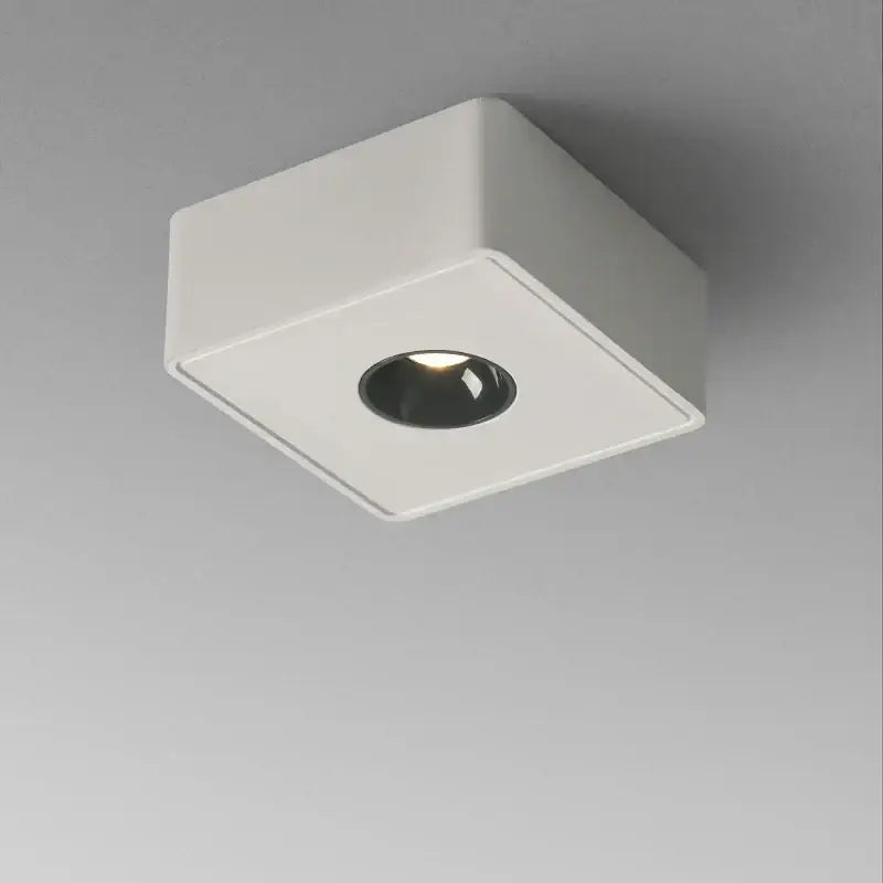 Modern black square led ceiling light with white surface and black circular center emitting warm illumination decorbites 12w