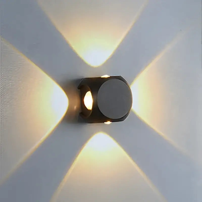 Modern black metal led wall light with circular face emitting warm directional light for outdoor garden decor