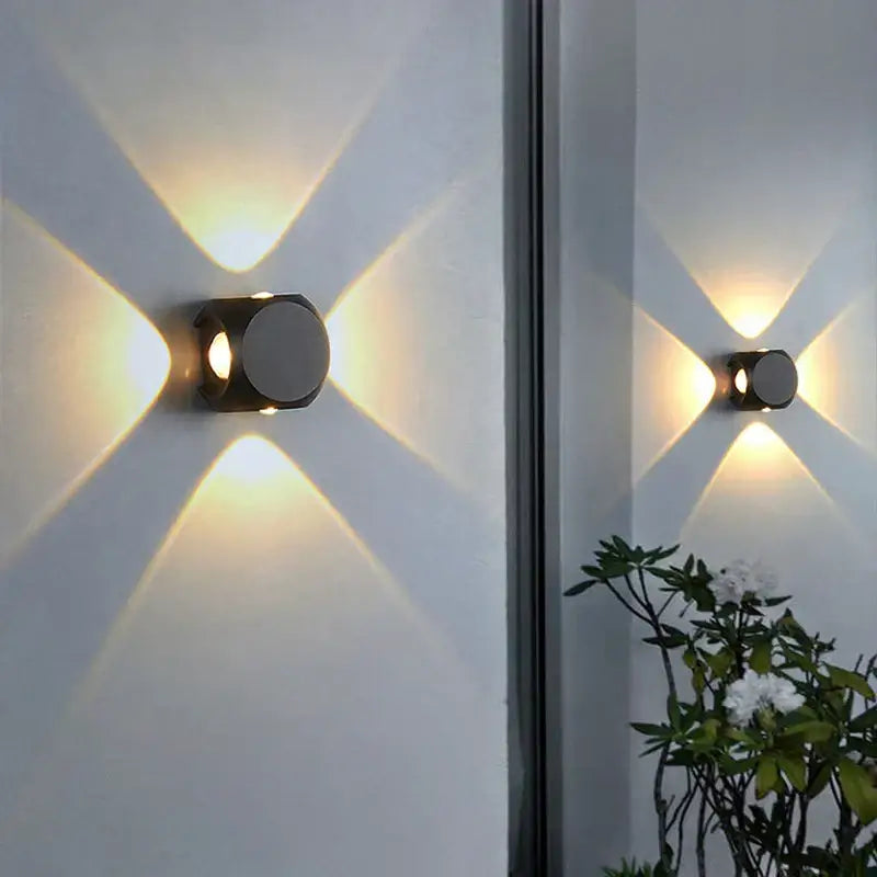 Modern black and silver square led wall light with geometric design casting warm starburst light for outdoor decor