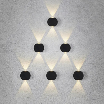 Modern black square led wall light garden sconce with six circular black led wall lights in a triangular pattern emitting warm white light