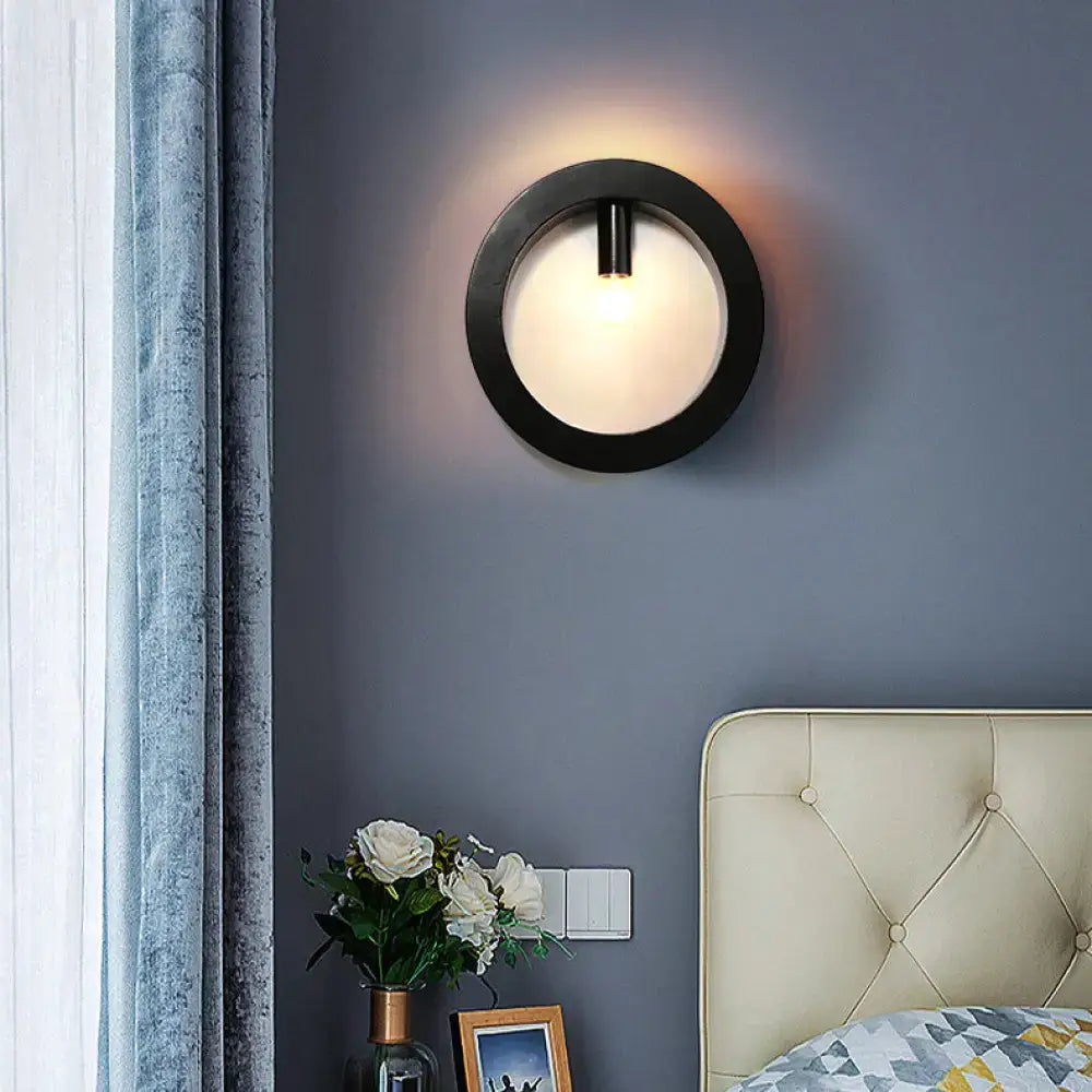 Modern black wall sconce lamp with frosted glass center and sleek circular design for bathroom lighting