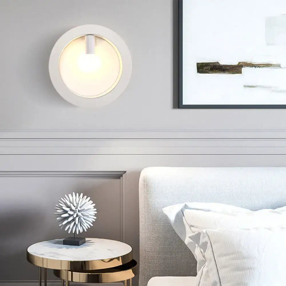 Modern white circular wall sconce lamp with warm glow and frosted glass for bathroom lighting