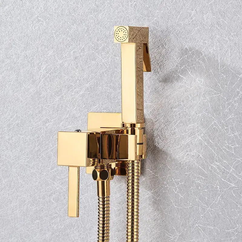Gold-finished modern brass bidet faucet with sleek rectangular design and two flexible hoses by decorbites