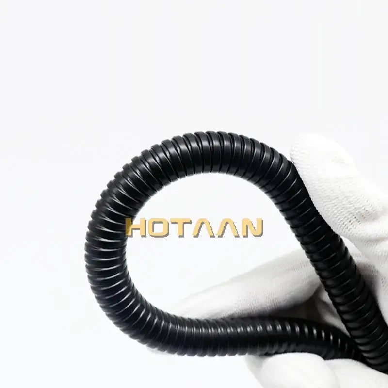 Black corrugated plastic conduit held in white glove representing flexible shower hose black stainless steel pipe