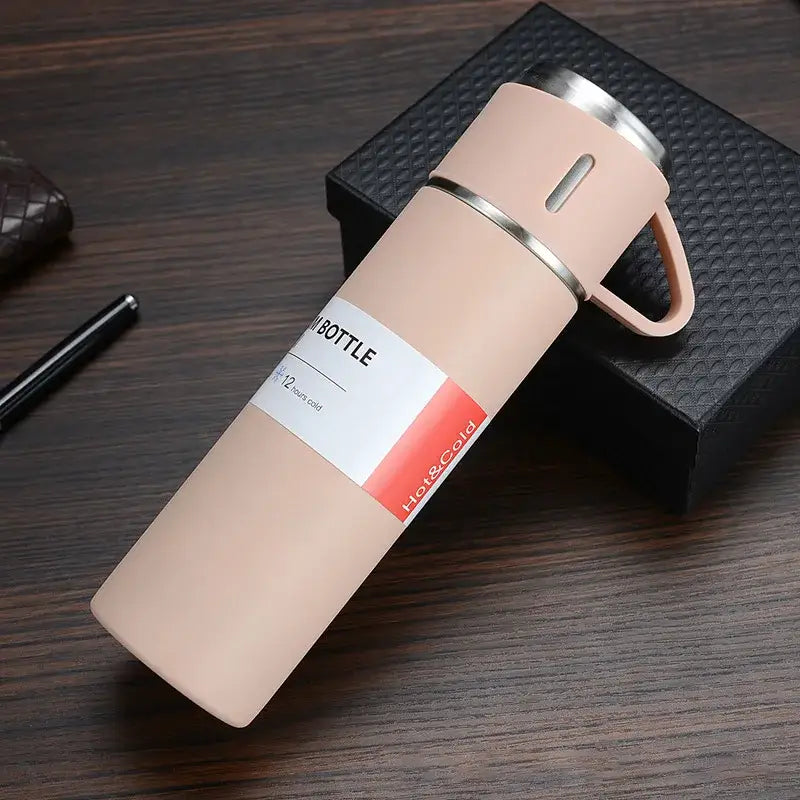 Beige vacuum insulated water mug with stainless steel lid and handle featuring minimalist hot and cold label