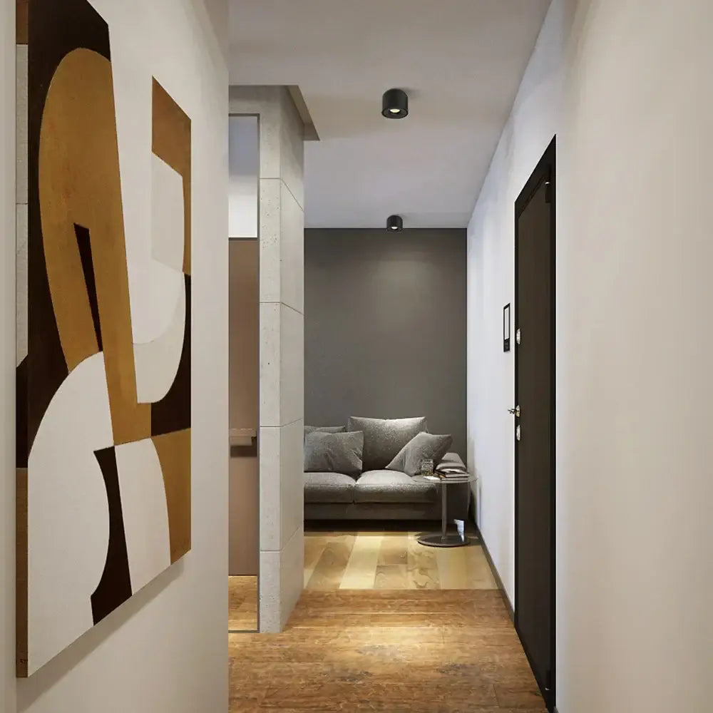 Modern black surface mount ceiling light for hallways with abstract wall art featuring bold tan white and black geometric shapes