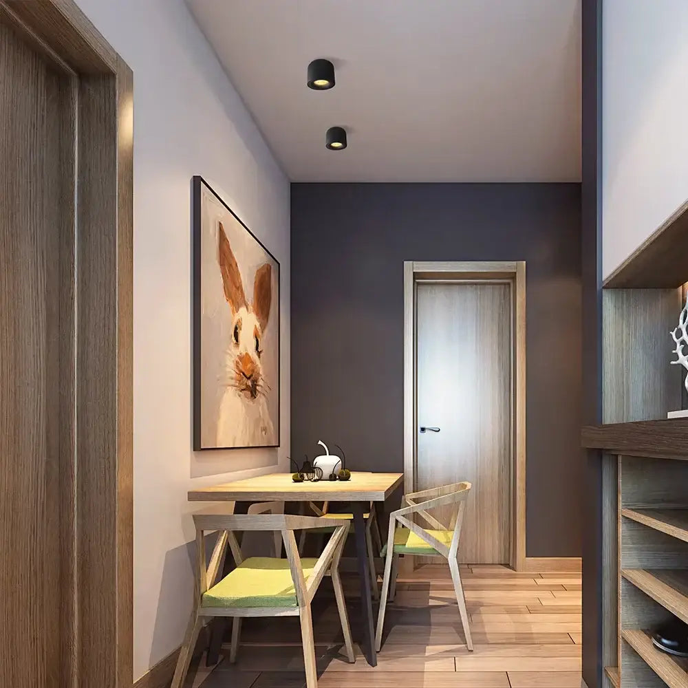 A framed canvas painting of a realistic beige rabbit under a modern black surface mount ceiling light for hallways