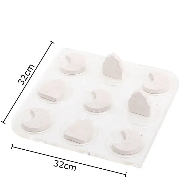 A clear plastic tray with nine light gray silicone molds for decorbites acrylic tic-tac-toe chessboard set decor
