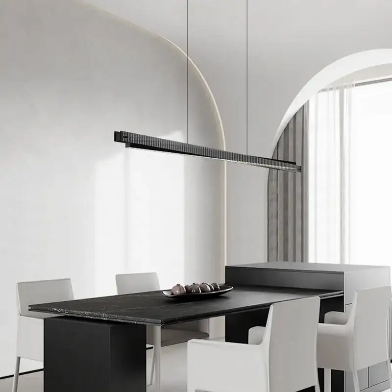 Modern black textured bar shape pendant light with ribbed surface suspended above dining table decorbites bar shape